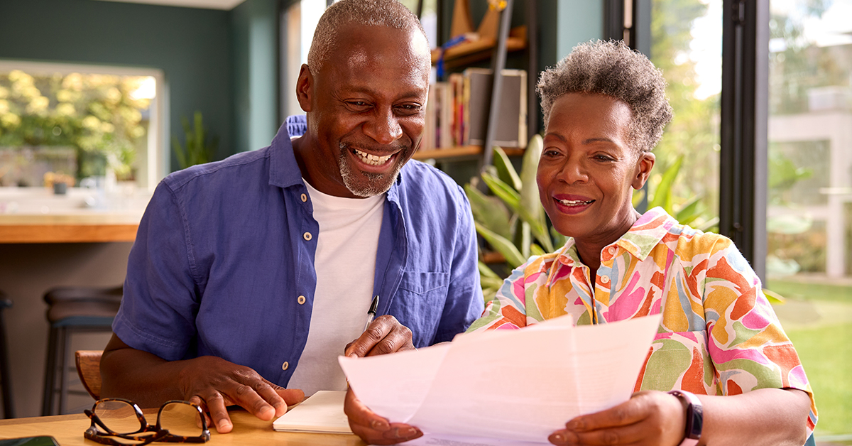 Couple reviewing financial documents together at home for their financial check-in.