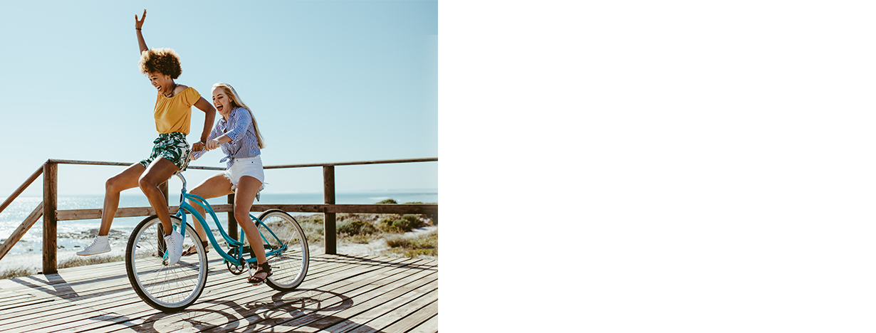 Two women riding a bike at the beach in Palm Beach County