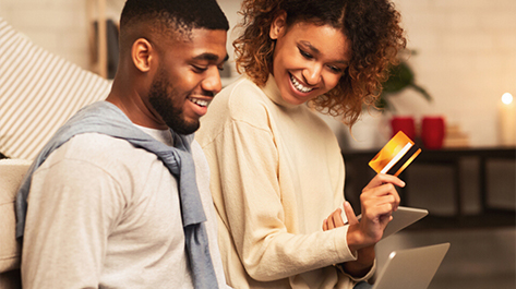 Couple looking over the benefits of using a credit card through their laptop
