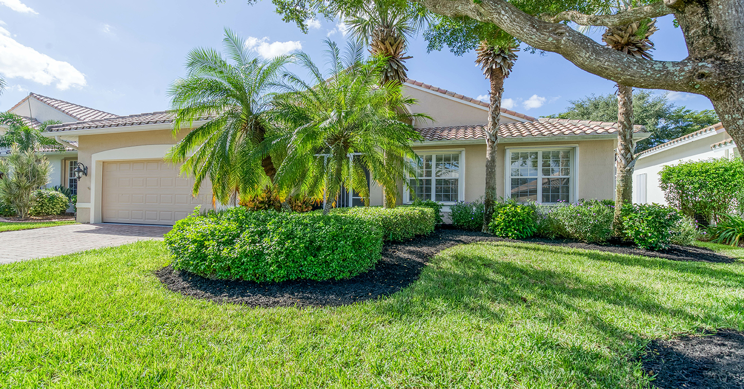 Single family home with palm trees and landscaped yard in a Palm Beach County neighborhood, representing home buying in South Florida.